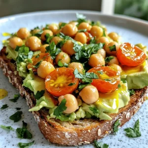To make smashed chickpea avocado toast, you need simple, fresh ingredients. Here’s what you will need: - Canned chickpeas - Ripe avocado - Lemon juice - Tahini - Garlic - Spices (salt, pepper, cumin) - Whole grain bread - Cherry tomatoes - Fresh herbs (cilantro or parsley) - Olive oil Each ingredient plays a key role in flavor and nutrition. Canned chickpeas give protein and fiber. Ripe avocado adds creaminess and healthy fats. Lemon juice brightens the dish. Tahini brings a nutty taste. Garlic adds depth. Spices like salt, pepper, and cumin enhance the overall flavor. Whole grain bread offers a hearty base. Cherry tomatoes add freshness and color. Fresh herbs like cilantro or parsley finish the dish with a burst of flavor. Olive oil gives a rich finish. For the full recipe, check out the detailed guide. This dish is not just tasty; it is also quick and healthy! - Draining and rinsing chickpeas Open the can of chickpeas. Pour them into a strainer. Rinse them under cool water to remove any extra salt. This step keeps your dish fresh and clean. - Mashing chickpeas Place the drained chickpeas in a bowl. Use a fork or potato masher to smash them. Leave some chickpeas whole for extra texture. This will give your toast a hearty feel. - Preparing the avocado mixture Cut the ripe avocado in half. Remove the pit and scoop the flesh into the bowl. Add lemon juice, tahini, minced garlic, salt, pepper, and cumin. Mix gently until everything is combined. Taste it and adjust the salt or lemon if needed. - Toasting bread While you prepare the mixture, toast your whole grain bread. Set your toaster to a medium setting. Aim for golden brown and crispy slices. This gives a nice crunch to your toast. - Spoon the chickpea and avocado mix onto bread Take your toasted bread and place it on a plate. Generously scoop the chickpea and avocado mix onto each slice. Spread it out evenly to cover the whole piece. - Topping ideas for extra flavor You can add halved cherry tomatoes on top. They add a pop of color and taste. Fresh cilantro or parsley makes it look nice too. Drizzle some olive oil for a rich finish. Enjoy your tasty creation! For the full recipe, check out the details above. To get the best texture, mash the chickpeas gently. You want some chunks for bite. Use a fork or potato masher for this. Don't over-mash; a mix of smooth and chunky is great. Add the avocado next. It should be ripe and creamy. Mix it in with the chickpeas. This creates a rich blend. For seasoning, start with salt and pepper. Add a little cumin for warmth. Taste as you go. You can always add more, but you can’t take it out! Pair your toast with a refreshing drink. Lemonade or iced tea works well. These drinks balance the toast's creaminess. Think about when to serve this dish. It’s perfect for brunch or a light lunch. You can also enjoy it as a snack. Serve it at gatherings for a fun treat. Everyone loves a tasty toast! For the full recipe, check out the Full Recipe. {{image_2}} If you want to change things up, try different ingredients. You can use sunflower seed butter instead of tahini. It gives a nice nutty flavor. You can also go for Greek yogurt for creaminess. As for bread, whole grain is great, but you can use sourdough or rye instead. Gluten-free bread works too, if you need it. Add toppings to boost nutrition and flavor. Some great options are sliced radishes or cucumbers. They add crunch and freshness. You can also sprinkle on feta cheese for a salty kick. Want more spice? Try adding smoked paprika or red pepper flakes. They give the toast a warm, zesty flavor. Adding herbs like basil or dill can also brighten the taste. Explore different spices and toppings to find what you love! For the full recipe, check out the Smashed Chickpea Avocado Toast. To keep your smashed chickpea avocado toast fresh, store it in an airtight container. This helps keep the flavors in and the air out. Use a glass or plastic container with a tight seal. It’s best to store the chickpea and avocado mix separate from the bread. This way, the bread stays crisp. If you store them together, the bread may get soggy. You can keep leftovers in the fridge for up to two days. When reheating, keep the bread and topping separate. Toast the bread again in a toaster or skillet. This helps regain the crunchy texture. For the chickpea and avocado mix, warm it gently in a microwave. Heat it in short bursts, about 15 seconds at a time. Stir between each burst to avoid hot spots. This way, you keep the creamy texture without losing flavor. Enjoy your meal as if it was freshly made! Can I make this toast vegan? Yes! This recipe is already vegan. It uses chickpeas and avocado. Both are plant-based. You can enjoy this toast without any animal products. How long does it take to prepare? This dish takes about 10 minutes to prep. Adding in toasting time, the total is around 20 minutes. It’s a quick meal for busy days. What are the nutritional benefits of chickpeas? Chickpeas are packed with protein and fiber. They help keep you full. They also contain many vitamins and minerals. This makes them a healthy choice for your diet. Can I prepare the mixture in advance? Yes! You can make the chickpea and avocado mix ahead of time. Store it in the fridge for up to two days. Just stir before serving to mix the flavors again. For the full recipe, visit the link. What bread works best for this recipe? I love using whole grain bread for this recipe. It adds texture and flavor. The nutty taste pairs well with the creamy chickpeas and avocado. You can also try sourdough or rye bread for a fun twist. Are there gluten-free options available? Yes, you can use gluten-free bread. Many brands offer great-tasting options. Look for whole grain or seed-based options to keep it healthy and tasty. Can I freeze smashed chickpea avocado toast? I do not recommend freezing the toast itself. The bread gets soggy when thawed. However, you can freeze the chickpea and avocado mix. Just store it in an airtight container. When ready, thaw it and spread it on fresh toast. This blog post covered how to make tasty smashed chickpea avocado toast. We discussed key ingredients, preparation steps, and tips for perfecting the texture. You learned about variations and how to store leftovers. Making this toast is simple and fun. You can enjoy it for breakfast or a snack. Try different toppings for more flavor. With this guide, you'll create a delicious, healthy dish every time. Enjoy your cooking journey!