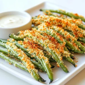 Start with 1 pound of fresh green beans. Trim the ends to keep them neat. Rinse them well and pat them dry. This helps them crisp up nicely. For the coating, you need: - 1 cup breadcrumbs (panko works great for extra crunch) - 1/2 cup grated Parmesan cheese - 1 teaspoon garlic powder - 1 teaspoon onion powder - 1/2 teaspoon smoked paprika - 1/4 teaspoon cayenne pepper (add this if you want some heat) - Salt and pepper, to taste Mix all these together in a shallow bowl. This blend gives the green beans a tasty crust. The seasoning mix is key for flavor. Garlic powder and onion powder add depth. Smoked paprika gives a nice, subtle smokiness. The cayenne pepper adds a kick, but it’s optional. Adjust the salt and pepper as you like. This mixture ensures each fry is packed with flavor! First, you need to preheat your air fryer to 400°F (200°C). This step helps the green beans cook evenly and get crispy. Make sure you let it heat up while you prepare the green beans. A hot air fryer is key for that perfect crunch. Rinse the fresh green beans under cold water. Trim the ends off each bean. Pat them dry with a paper towel. This helps the coating stick better. Next, grab two bowls. In one bowl, mix together: - 1 cup breadcrumbs (panko works great for crunch) - 1/2 cup grated Parmesan cheese - 1 teaspoon garlic powder - 1 teaspoon onion powder - 1/2 teaspoon smoked paprika - 1/4 teaspoon cayenne pepper (if you want some heat) - Salt and pepper to taste In the other bowl, beat two large eggs until smooth. Now, dip each green bean into the egg. Make sure it’s coated all over. Then roll it in the breadcrumb mix. Press down a bit to make sure it sticks well. Once all the green beans are coated, lay them in a single layer in the air fryer basket. Make sure they are not touching each other. This helps them crisp up better. Lightly spray the green beans with olive oil. This step adds flavor and helps with the crunch. Now, air fry the green bean fries for 8 to 10 minutes. Shake the basket halfway through to ensure they cook evenly. You want them golden brown and crispy when done. After cooking, carefully remove the green beans from the air fryer. Let them cool for a couple of minutes before serving. Enjoy them fresh and crispy! To make your green bean fries extra crispy, use panko breadcrumbs. Panko gives a light, crunchy texture. Coat the beans well in the breadcrumb mix. Press down lightly while coating. This helps the crumbs stick better. Also, make sure to spray them lightly with olive oil. The oil helps in achieving that golden brown color. For dipping, I love serving these fries with ranch or spicy aioli. The cool ranch balances the heat well. You can also try a zesty garlic dip or homemade tzatziki. These sauces add more flavor and fun to the meal. Don’t be afraid to experiment with your favorites! One common mistake is overcrowding the air fryer basket. This can lead to uneven cooking and soggy fries. Always arrange them in a single layer. Another mistake is not drying the beans. Wet beans won’t get crispy. Pat them dry with a paper towel after washing. Lastly, watch the cooking time closely. Each air fryer cooks a bit differently, so check for that perfect golden color! {{image_2}} You can change the flavor of your green bean fries with different seasonings. Try adding Italian herbs like oregano or basil. You can also use taco seasoning for a fun twist. If you love heat, sprinkle some chili powder or cayenne pepper into the breadcrumb mix. Don't be afraid to get creative! For a vegetarian option, keep the recipe as is. Just make sure your breadcrumbs are vegetarian. For a gluten-free version, use gluten-free breadcrumbs or crushed rice crackers. This way, everyone can enjoy these tasty fries. You can mix green beans with other veggies for different textures and flavors. Try adding zucchini, carrots, or bell peppers. Cut them into similar sizes so they cook evenly. This will make your dish colorful and fun! It’s a great way to use up leftover veggies too. After you enjoy your crispy green bean fries, store any leftovers in an airtight container. This helps keep the fries fresh and maintains their crunch. Place the container in the fridge. They will stay good for about 3 days. To reheat the fries and keep them crispy, use your air fryer. Preheat it to 350°F (175°C). Place the fries in the basket without overcrowding. Heat them for about 3-5 minutes. This method revives their crunchiness. You can also use an oven, but the air fryer works best. You can freeze these green bean fries for later. First, let them cool completely. Then, place them on a baking sheet in a single layer. Freeze them for a few hours until solid. Once frozen, transfer them to a freezer bag. They will keep well for up to 3 months. When ready to eat, cook them straight from the freezer in the air fryer at 400°F (200°C) for about 10-12 minutes. Enjoy your crispy treat any time! Yes, you can use frozen green beans. However, they may not be as crispy. If you use them, let them thaw first. Pat them dry with a towel. This step helps remove extra moisture. Less moisture means crispier fries! To add heat, use more cayenne pepper. You can also add red pepper flakes. Mix them into the breadcrumb mix for extra spice. If you love heat, try a spicy dipping sauce too! Look for air fryers with at least a 3-quart capacity. Models with a basket design work best. Brands like Philips, Ninja, and Cosori get great reviews. They cook evenly and make your fries crispy. Consider one with adjustable temperature settings for more control. In this post, we explored how to prepare air-fried green beans. We covered fresh ingredients, step-by-step cooking, and tips for perfect crispiness. You learned about different seasonings and how to store leftovers. Air frying is a fun way to enjoy healthy snacks or sides. With practice, you will master this simple recipe. Share it with friends and try your own twists. Enjoy your tasty and crispy green beans!