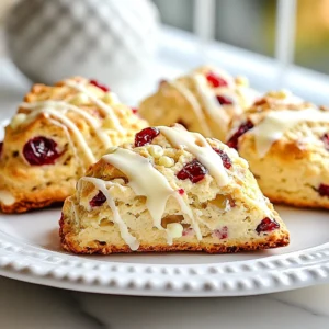 - 2 cups all-purpose flour - 1/4 cup granulated sugar - 1 tablespoon baking powder - 1/2 teaspoon baking soda - 1/2 teaspoon salt - 1/2 cup cold unsalted butter, cubed - 3/4 cup buttermilk - 1/2 cup dried cranberries - 1/2 cup white chocolate chips - 1 large egg (for egg wash) I use all-purpose flour because it gives the scones a nice rise. Granulated sugar adds sweetness, while baking powder helps them puff up. Baking soda and salt enhance the flavors. I love using cold butter for a flaky texture. Buttermilk adds moisture and a slight tang. Dried cranberries give a chewy bite, and white chocolate chips add creaminess. The egg wash gives the scones a golden color. - Fresh cranberries for garnish - Additional white chocolate for drizzling Fresh cranberries on top make the scones look lovely. A drizzle of white chocolate adds an extra treat. You can get creative and use what you like! {{ingredient_image_1}} - Preheat your oven to 400°F (200°C). Line a baking sheet with parchment paper. - In a large mixing bowl, whisk together 2 cups of flour, 1/4 cup of sugar, 1 tablespoon of baking powder, 1/2 teaspoon of baking soda, and 1/2 teaspoon of salt. Mix until well combined. - Add 1/2 cup of cold, cubed butter to the flour mixture. Use a pastry cutter or your fingers to mix until it looks like coarse crumbs. - Stir in 1/2 cup of dried cranberries and 1/2 cup of white chocolate chips. Make sure they are evenly mixed into the flour. - Pour in 3/4 cup of buttermilk. Gently mix with a spatula until the dough is just moist. Don’t overmix; the dough should feel a bit sticky. - Turn the dough out onto a floured surface and pat it into a circle, about 1 inch thick. Cut it into 8 wedges or use a biscuit cutter for round scones. - Place the scones on the prepared baking sheet. Beat 1 egg in a small bowl and brush it over the tops for a golden finish. - Bake for 15-20 minutes, until the scones are lightly golden on top. Let them cool on the baking sheet for a few minutes before moving to a wire rack. To make great scones, use cold ingredients. Cold butter helps the scones rise well. It also keeps them flaky. When you mix the butter, stop when it looks like coarse crumbs. This keeps the dough light and airy. If you mix too much, your scones will be tough. You can change the flavor of your scones easily. Adding spices like cinnamon or nutmeg gives extra warmth. A little can go a long way. Use high-quality chocolate for a rich taste. It makes a big difference in your scones. Always choose chocolate you love to eat. Pro Tips Use Cold Ingredients: Ensure your butter and buttermilk are cold to help create flaky layers in the scones. Don’t Overmix: Mix the dough until just combined to prevent tough scones; a little stickiness is okay! Bake on Parchment: Using parchment paper on your baking sheet helps prevent sticking and ensures even baking. Experiment with Flavors: Feel free to add nuts or different dried fruits for a personalized twist on these scones. {{image_2}} You can play with the flavors in cranberry white chocolate scones. One easy swap is to use dried blueberries instead of cranberries. Blueberries add a sweet and tangy twist. They pair well with white chocolate for a yummy treat. Another fun change is to use dark chocolate instead of white chocolate. Dark chocolate gives a richer taste. It also adds a nice contrast to the sweet berries. Try both variations to find your favorite! If you need gluten-free scones, you can use a gluten-free flour mix. Many brands offer blends that work well in baking. Just make sure to follow the package instructions for the best results. For a vegan option, swap the buttermilk with plant-based milk. Add a tablespoon of vinegar to create a buttermilk substitute. Replace the egg wash with a splash of almond milk or a sprinkle of water. These changes make your scones vegan-friendly without losing flavor. After baking your cranberry white chocolate scones, let them cool on a wire rack. This step is key. Cooling helps keep them from getting soggy. Once they are cool, place them in an airtight container. This keeps them fresh and moist. You can store them at room temperature for up to three days. If you want to keep them longer, consider freezing them. To enjoy your scones at their best, reheating is simple. You can use an oven or a toaster oven. Preheat the oven to 350°F (175°C). Place your scones on a baking sheet for about 5-10 minutes. This method helps maintain their crisp edges. You may also microwave them. Heat for about 10-15 seconds, but be careful. Microwaving can make them a bit soggy. Always check and adjust time as needed. Enjoy your scones warm and fresh! You can prepare the dough the night before. Mix the dry ingredients and add the butter. Then, stir in the cranberries and chocolate. Cover the bowl and store it in the fridge. In the morning, add the buttermilk and shape the scones. This saves time and keeps fresh flavors. Yes, you can freeze the scones. After cutting them, place them on a tray. Freeze them for about 30 minutes. Then, move them to a freezer bag. They will stay good for up to three months. Bake them straight from the freezer, adding a few extra minutes to the baking time. Scones pair well with many treats. Try serving them warm with butter or jam. A drizzle of melted white chocolate adds a nice touch. You can also serve them with a hot cup of tea or coffee. Fresh fruit or whipped cream can make for a lovely addition too. You now have all the steps to make delicious cranberry white chocolate scones. From picking the right ingredients to storage tips, I’ve covered it all. Remember to use cold butter and not to overmix for the best texture. You can personalize scones with dried fruits or try gluten-free options. Enjoy crafting your tasty treats and sharing them with loved ones. These scones are sure to impress and delight everyone who tries them. Happy baking!
