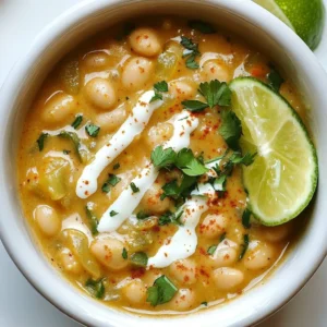 - 2 cans (15 oz each) white beans (cannellini or great northern), drained and rinsed - 1 tablespoon olive oil - 1 onion, diced - 3 cloves garlic, minced - 1 green bell pepper, diced - 1 jalapeño, minced (seeds removed for less heat) - 1 teaspoon ground cumin - 1 teaspoon smoked paprika - 1/2 teaspoon cayenne pepper (adjust for spice level) - 4 cups vegetable broth - 1 cup corn kernels (fresh or frozen) - 1/2 cup heavy cream (or coconut milk for a dairy-free option) - Salt and pepper to taste - Fresh coriander (cilantro) for garnish - Lime wedges for serving This recipe shines with a few key ingredients. The white beans bring a creamy texture and a nutty flavor. I often use cannellini or great northern beans. They are perfect for this dish. Fresh vegetables add color and taste. I like to use onion, garlic, green bell pepper, and jalapeño. The onion and garlic form the base flavors. The peppers add crunch and a bit of heat. Spices are essential for depth. Ground cumin gives warmth and earthiness. Smoked paprika adds a rich, smoky taste. Don’t forget the cayenne pepper! It adds a kick, but you can adjust it to suit your taste. The liquid components create the chili's base. Vegetable broth is my go-to for flavor and richness. Heavy cream makes it silky and rich. If you prefer a lighter option, use coconut milk. Finally, I love adding fresh coriander and lime wedges as garnishes. They bring brightness and freshness to each bowl. These ingredients work together to create a comforting and flavorful dish. {{ingredient_image_1}} 1. Cooking the aromatics: Start by heating 1 tablespoon of olive oil in a large pot over medium heat. Add 1 diced onion and cook until it turns soft, about 5 minutes. Then, stir in 3 minced garlic cloves, 1 diced green bell pepper, and 1 minced jalapeño (remove seeds for less heat). Cook these for 3 to 4 minutes until they soften. 2. Adding spices and creating flavor: Sprinkle in 1 teaspoon of ground cumin, 1 teaspoon of smoked paprika, and 1/2 teaspoon of cayenne pepper. Stir well to coat the veggies with the spices. Cook this mix for 1 to 2 minutes until it smells great. 3. Incorporating broth, beans, and corn: Pour in 4 cups of vegetable broth, then add 2 cans of drained white beans and 1 cup of corn kernels. Bring this mixture to a boil. After boiling, reduce the heat and let it simmer for 15 to 20 minutes. This helps all the flavors mix together. 1. Mashing beans for creaminess: Grab a potato masher or fork and gently mash some of the beans in the pot. This adds a nice creamy texture to the chili. 2. Adding cream or coconut milk: Stir in 1/2 cup of heavy cream or coconut milk for a dairy-free option. Let it simmer for another 5 minutes to blend the flavors. 3. Adjusting seasoning and serving temperature: Taste the chili and add salt and pepper as needed. Remove it from heat and let it cool slightly before serving. Adjusting spice levels to taste Start with small amounts of spices. You can always add more later. If you like heat, keep the jalapeño seeds in. For less heat, remove them. Always taste as you cook. This lets you find your perfect balance. Tips for enhancing creaminess For a creamier chili, mash some beans in the pot. Use a potato masher or fork. You can also add more heavy cream or coconut milk. This will make it rich and smooth. Suggested cooking times for optimum flavor Cook your onions and garlic until soft. This usually takes about 5 minutes. After adding spices, let them cook for 1-2 minutes. This helps release their flavors. Simmer the chili for 15-20 minutes. This allows all the flavors to blend well. Ideal accompaniments: tortilla chips and crusty bread Serve your chili with crunchy tortilla chips. They add a fun texture. Crusty bread is also great for dipping. Both pair well with the creamy chili. Garnishing tips for presentation When serving, ladle chili into bowls. Then, sprinkle fresh coriander on top. Add a lime wedge on the side for a burst of flavor. This makes your dish look vibrant and inviting. Pro Tips Adjust the Spice Level: If you prefer a milder chili, be sure to remove the seeds from the jalapeño and use less cayenne pepper. Make it Creamy: For an extra creamy texture, mash more of the beans while cooking, or blend a portion of the chili and stir it back in. Garnish for Flavor: Fresh coriander and lime juice not only add color but also enhance the overall flavor of the chili, making it more vibrant. Serve with Sides: Pair this chili with tortilla chips, crusty bread, or even over rice for a heartier meal. {{image_2}} You can switch up the beans in this dish. Try black beans or pinto beans for a twist. Each type brings its own taste and texture. If you want a vegan option, use coconut milk instead of heavy cream. It still gives the chili a creamy feel. You can also skip the cream entirely if you prefer. Adding extra veggies can make this chili even better. Try carrots, zucchini, or spinach for added nutrition. You can even toss in some cooked chicken or turkey for extra protein. This dish is all about making it yours. To change the flavor, use different spice blends. For a smoky taste, add chipotle powder. If you want a fresh kick, a touch of lime zest can brighten it up. You can also mix in herbs like thyme or oregano for depth. If you like heat, try adding other peppers. Serrano or habanero peppers can crank up the spice level. For a milder option, you can use sweet bell peppers. Remember to adjust the cayenne pepper based on your heat preference. Get creative and make this chili fit your taste! To store leftover creamy white bean chili, let it cool first. Then, place it in an airtight container. Store it in the fridge. This chili stays fresh for about 4 to 5 days. For freezing, use a freezer-safe container. Leave some space at the top for expansion. This chili can last up to 3 months in the freezer. When you’re ready to eat, thaw it overnight in the fridge. Reheat it on the stove over medium heat for the best texture. Stir it often to keep it smooth. You can also use a microwave, but watch it closely to avoid hot spots. Enjoy your warm, comforting chili again! Can I make this chili in a slow cooker? Yes, you can make creamy white bean chili in a slow cooker. Start by sautéing the onion, garlic, and peppers in a pan. Then, add them to the slow cooker with the other ingredients. Cook on low for 6-8 hours or on high for 3-4 hours. Stir in the cream or coconut milk near the end for a nice finish. How do I thicken the chili if it’s too watery? If your chili is too watery, there are a few options. You can mash some beans with a fork or potato masher. This adds creaminess and helps thicken the chili. Another option is to simmer the chili uncovered for a bit, allowing some liquid to evaporate. What can I serve with creamy white bean chili? Creamy white bean chili pairs well with many sides. I recommend serving it with tortilla chips for crunch. Crusty bread also works great for dipping. For a fresh touch, add a lime wedge and some fresh coriander on top. This adds flavor and a nice color to your dish! You learned about the key ingredients for creamy white bean chili and how to make it. The step-by-step guide showed you how to build flavor and get the right texture. Tips and tricks can help you perfect this dish to your taste. You also discovered ways to customize and store your chili. Experimenting with variants and serving ideas can make each meal special. Enjoy your cooking journey and create a chili that suits you best!