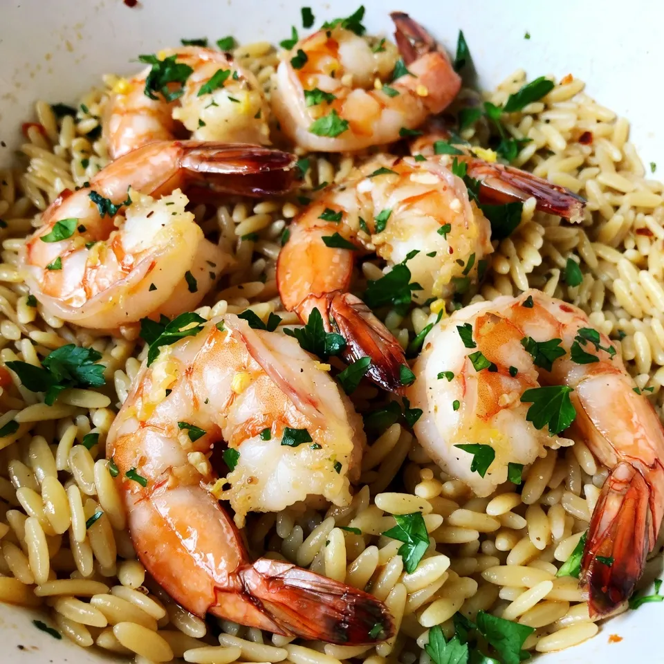 - 1 pound large shrimp, peeled and deveined - 1 cup orzo pasta - 4 garlic cloves, minced - 1 lemon (zested and juiced) - 2 cups vegetable broth - 2 tablespoons olive oil - 1 tablespoon butter - 1 teaspoon red pepper flakes (optional) - Salt and pepper to taste - Fresh parsley for garnish This dish starts with one pound of large shrimp. I love using shrimp because they cook quickly and taste great. The orzo pasta is next, and it adds a nice bite to the meal. You need one cup of orzo to soak up all those delicious flavors. Next, we have the flavor enhancers. Four minced garlic cloves give a strong taste. Garlic brings warmth and depth to the dish. A lemon, zested and juiced, adds bright flavor. The zest gives it a fresh kick, while the juice adds tang. Now, let’s look at the cooking essentials. You will need two cups of vegetable broth. This broth cooks the orzo and keeps it moist. For cooking, we use two tablespoons of olive oil and one tablespoon of butter. These fats help the garlic and shrimp sauté beautifully. If you want a little heat, you can add one teaspoon of red pepper flakes. Salt and pepper help bring out the other flavors. Lastly, fresh parsley is perfect for garnish. It adds color and a fresh taste when serving. Each ingredient plays an important role in making this lemon garlic shrimp orzo a standout dish. {{ingredient_image_1}} First, grab a medium saucepan. Pour in two cups of vegetable broth and bring it to a boil. Once boiling, add one cup of orzo pasta. Cook it according to the package instructions until it is al dente. This usually takes around 8-10 minutes. After cooking, drain the orzo and set it aside. This step is key for a tasty base. Now, take a large skillet and heat it over medium heat. Add two tablespoons of olive oil and one tablespoon of butter. Let them melt together. Next, toss in four minced garlic cloves. Sauté them for about 1-2 minutes until they smell great. Then, add one pound of peeled and deveined shrimp to the skillet. Season with salt, pepper, and red pepper flakes if you like it spicy. Cook for 2-3 minutes on one side, then flip. Cook for another 2-3 minutes until the shrimp turn pink and are fully cooked. Once the shrimp is done, pour in the juice and zest of one lemon. Stir it well to coat the shrimp in that bright flavor. Let it simmer for about a minute. Then, add the cooked orzo to the skillet. Gently toss everything together until the shrimp, orzo, and sauce mix well. Taste your dish and adjust the seasoning if needed. You want it just right! To cook shrimp just right, watch their color. They should turn pink and opaque. This takes about 4 to 6 minutes. Overcooked shrimp can become tough, so keep an eye on them. For seasoning, taste as you go. Add salt and pepper to suit your palate. You can also adjust the red pepper flakes for heat. A little zing goes a long way! You can prep this dish before serving. Cook the orzo and shrimp ahead of time. Store them in separate containers in the fridge. When ready to eat, just heat up the shrimp and orzo together. Add the lemon juice and zest right before serving. This keeps the flavors fresh. This dish shines on its own but pairs well with a simple side salad. A crisp green salad adds crunch and freshness. You could also serve it with garlic bread for a warm touch. If you want a heartier meal, consider a side of steamed veggies. Enjoy it however you like! Pro Tips Choose Quality Shrimp: Opt for fresh or frozen shrimp that are large and sustainably sourced for the best flavor and texture. Don’t Overcook the Shrimp: Cook shrimp just until they are pink and opaque to avoid a rubbery texture; they will continue to cook slightly after removing from heat. Use Homemade Broth: If possible, use homemade vegetable broth for a richer flavor compared to store-bought options. Garnish for Freshness: Adding fresh parsley just before serving brightens the dish and adds a pop of color, enhancing both presentation and flavor. {{image_2}} You can swap shrimp for chicken or tofu. Chicken gives a hearty bite. Cut chicken into small pieces and cook like shrimp. Tofu adds a nice twist. Use firm tofu and cube it. Cook it until golden brown for flavor. Adding vegetables can make this dish even better. Spinach is a great choice. Just toss it in at the end until it wilts. Tomatoes add a fresh taste. You can use cherry tomatoes or diced ones. Asparagus is another tasty option. Cut it into small pieces and sauté until tender. Feel free to change the flavor profile. Herbs can make a big difference. Try adding basil or cilantro for freshness. You can also use thyme or rosemary for a warm taste. For spice lovers, mix in cayenne pepper or smoked paprika. These changes keep the dish exciting and new. After you enjoy your Lemon Garlic Shrimp Orzo, store any leftovers in an airtight container. Make sure to cool the dish to room temperature first. This helps keep the shrimp fresh. In the fridge, it will last for up to three days. If you plan to eat it later, do not add the parsley until you reheat it. This keeps the garnish fresh and bright. You can freeze Lemon Garlic Shrimp Orzo if you want to save some for later. First, let it cool completely. Then, place it in a freezer-safe container. Make sure to remove as much air as possible to avoid freezer burn. You can freeze it for up to three months. When you are ready to eat it, thaw it in the fridge overnight before reheating. To reheat your Lemon Garlic Shrimp Orzo, you have a few options. The best way is to use a skillet. Heat a little olive oil over medium heat. Add the orzo and shrimp mixture, stirring gently until warmed through. You can add a splash of vegetable broth or water to help it stay moist. You can also use a microwave. Place it in a microwave-safe dish, cover it, and heat in short bursts, stirring in between. Make sure it is hot all the way through before serving. Yes, you can use frozen shrimp. Just make sure to thaw them first. Place the shrimp in cold water for about 15-20 minutes. Then, pat them dry before cooking. This way, they will cook evenly and absorb all the flavors. To add heat, sprinkle in more red pepper flakes. Start with half a teaspoon and taste as you go. You can also add diced jalapeños or a dash of hot sauce. These will give the dish a nice kick without overpowering the lemon and garlic. If you don't have orzo, use another small pasta like ditalini or couscous. Quinoa or rice can also work well. Just adjust the cooking time based on what you choose. This keeps the dish tasty and satisfying. Leftovers will stay fresh for about 3-4 days in the fridge. Store them in an airtight container to keep them flavorful. When you're ready to eat, just reheat in a skillet or microwave until warm. Enjoy it again! This article covered how to make a tasty shrimp orzo dish. You learned about the main ingredients and how to cook them perfectly. I shared tips for making the dish your own and ideas for storage. Remember, you can swap shrimp for chicken or tofu, and add your favorite veggies. Experiment with flavors to keep things fun. Enjoy this dish for a quick weeknight meal or impress guests with your new skills!